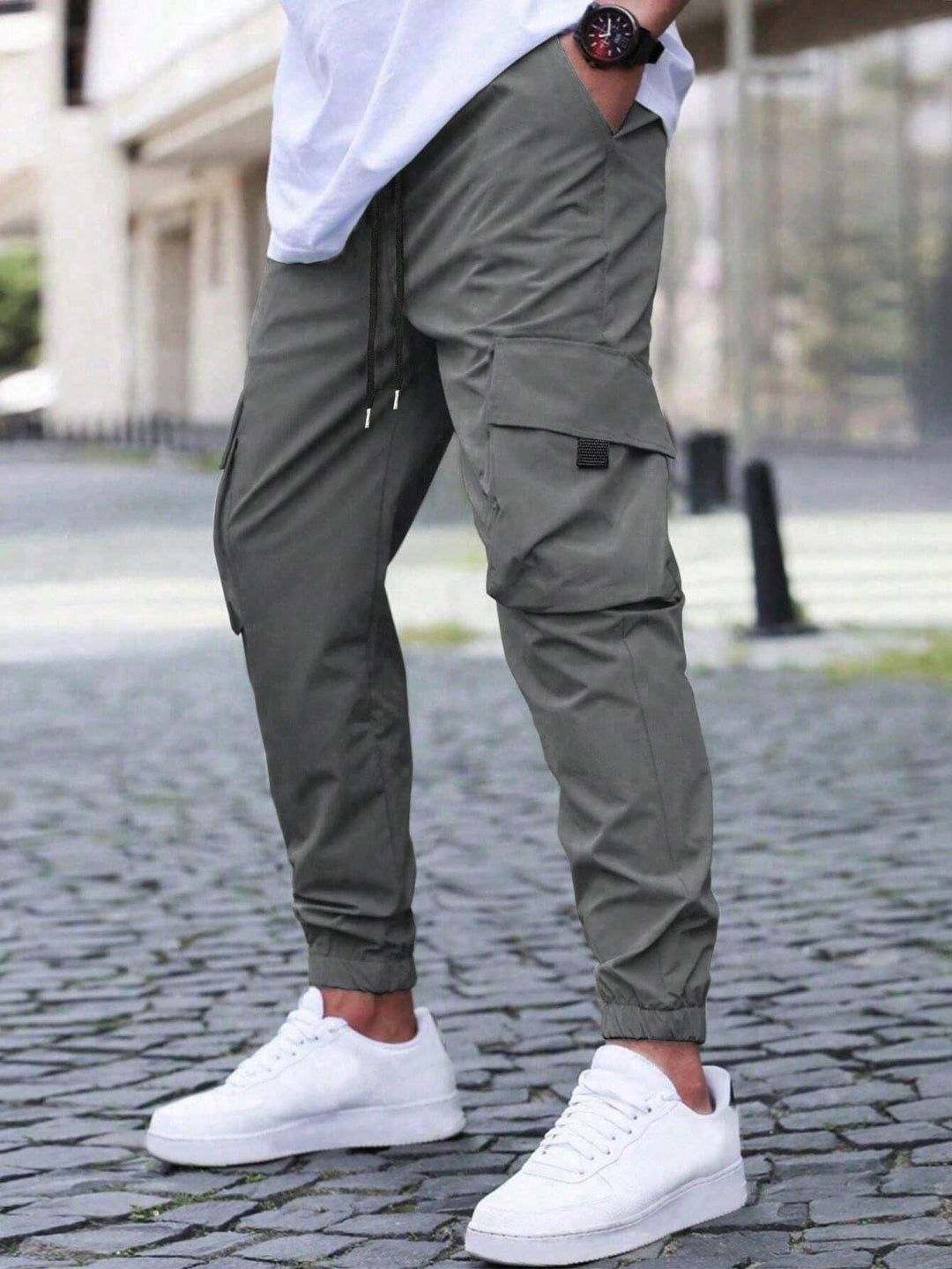 Primo piano tasche multitasche dei pantaloni cargo uomo slim fit, funzionalità e stile moderno per ogni avventura urbana.