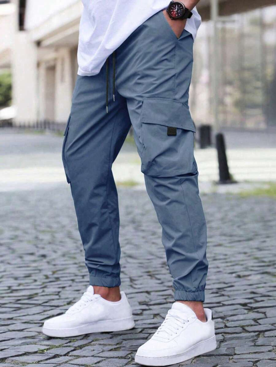 Uomo con pantaloni cargo slim fit versatili, abbinati a sneakers e t-shirt, ideali per un outfit moderno e casual.