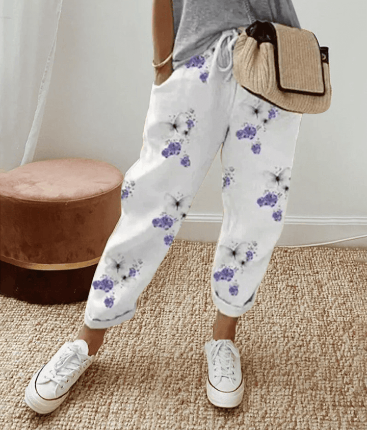 Donna che indossa pantaloni fluidi estivi, vita alta e colore neutro. Perfetti per un comfort elegante e alla moda.