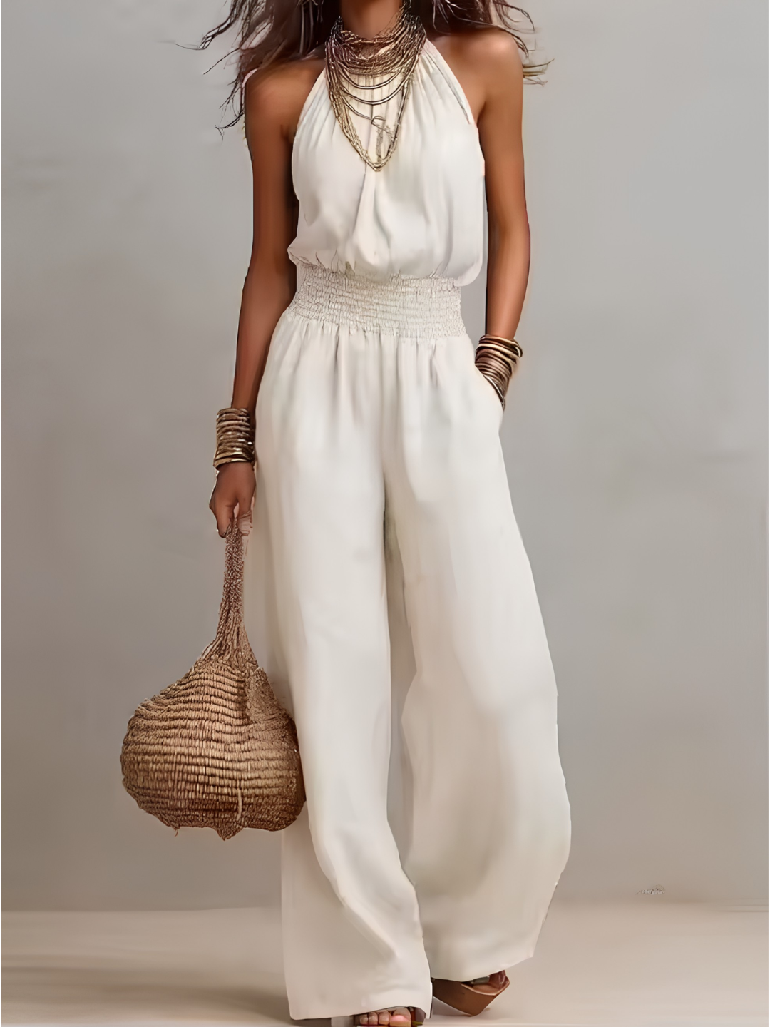 Tuta donna elegante con scollo halter e pantaloni larghi, perfetta per outfit casual chic estivi.