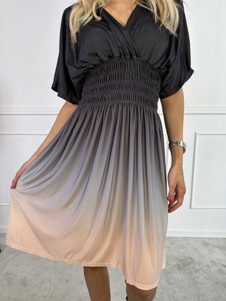 Modella indossa abito midi sfumato donna, scollo a V, stile estivo fluido e confortevole, colori vivaci.