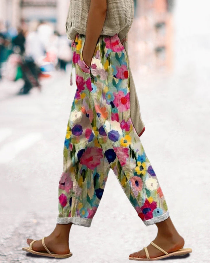 Dettaglio stampa floreale acquarello su pantaloni estivi donna. Tonalità vivaci per un look primaverile casual.