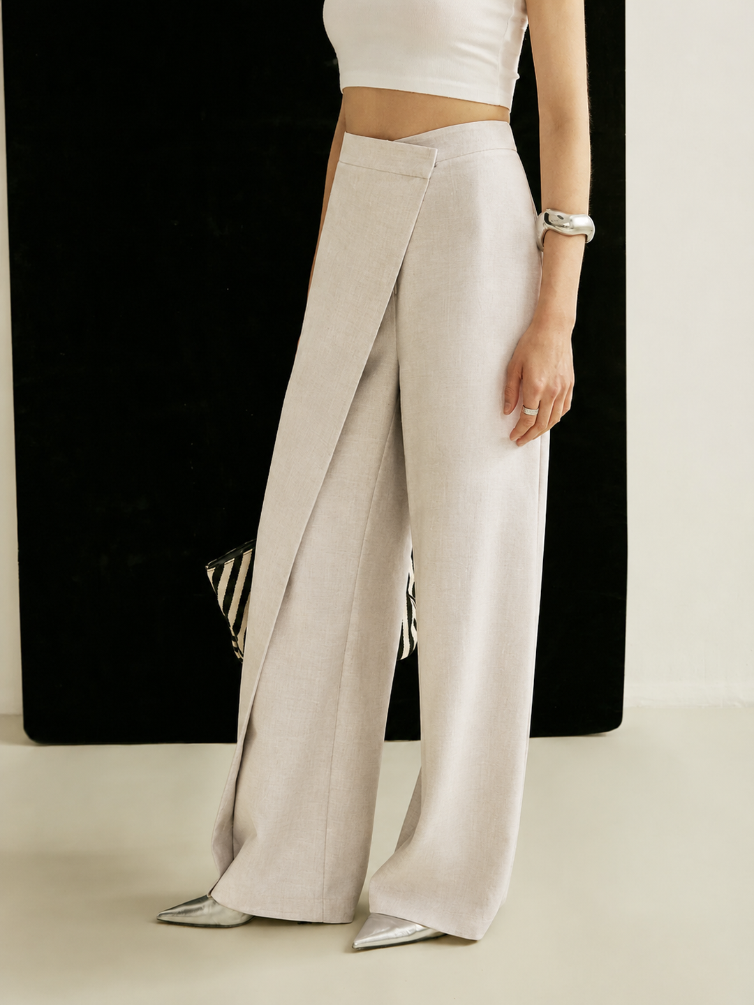 Pantaloni donna moderni a vita alta, con design asimmetrico e gamba larga, per uno stile unico e sartoriale.