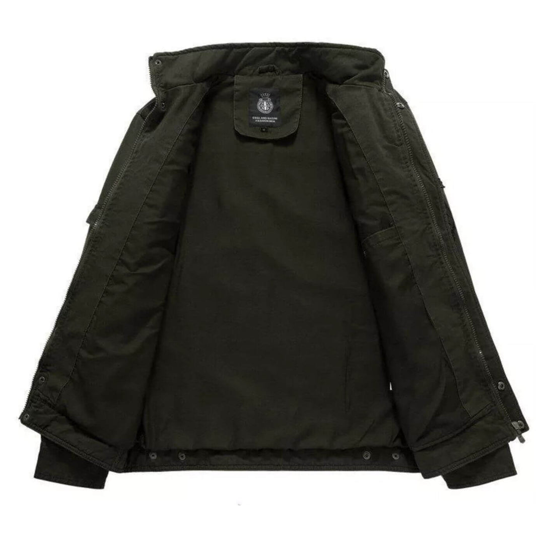 Uomo indossa giacca cargo militare verde con collo alto. Stile robusto e versatile per autunno e primavera.