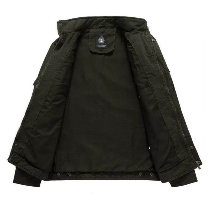 Uomo indossa giacca cargo militare verde con collo alto. Stile robusto e versatile per autunno e primavera.
