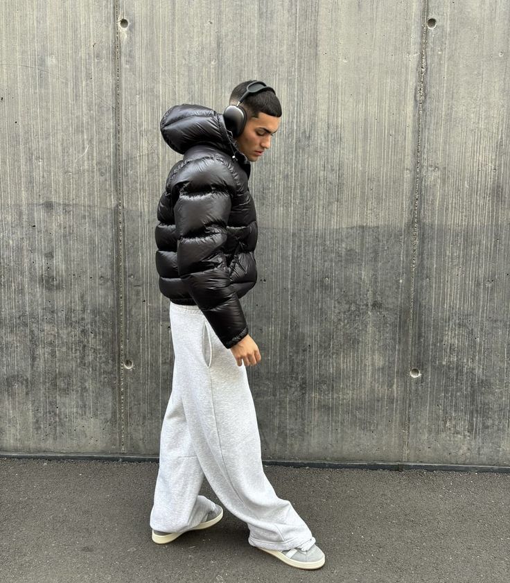 Giacca invernale uomo nera lucida con cappuccio, piumino casual elegante per affrontare il freddo urbano.