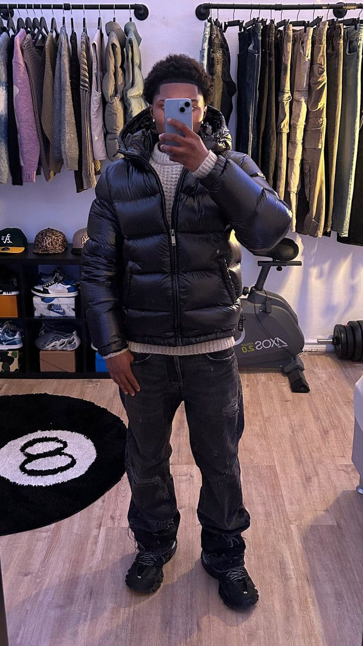 Piumino uomo lucido con cappuccio nero o verde. Giacca invernale che offre protezione dal freddo in stile urbano.