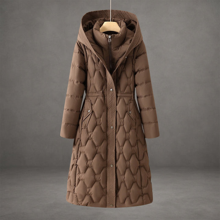 Elegante piumino donna lungo con cappuccio, trapuntato per massimo calore invernale. Moda outerwear.