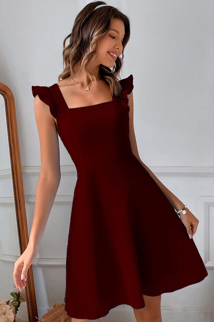 Vestito estivo donna, vista posteriore. Schiena aperta con laccetti incrociati e balze del mini abito.