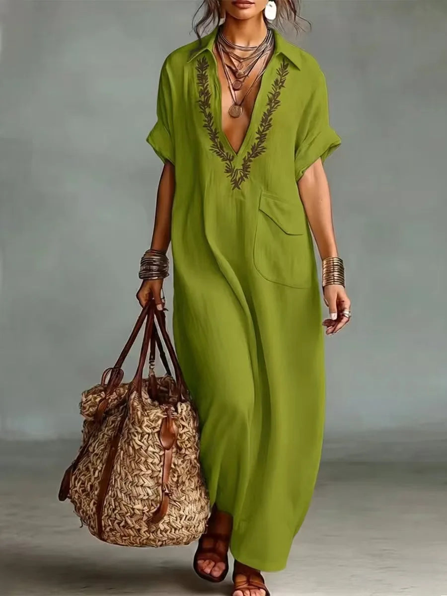 Dettaglio del ricco ricamo floreale sull'abito lungo boho donna, per un tocco chic estivo.