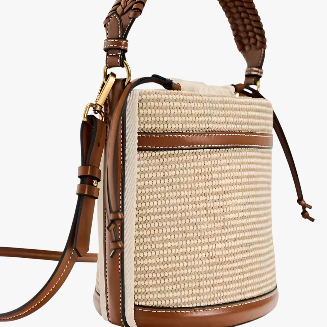 Elegante borsa a tracolla marrone in paglia intrecciata, ideale per outfit estivi chic.