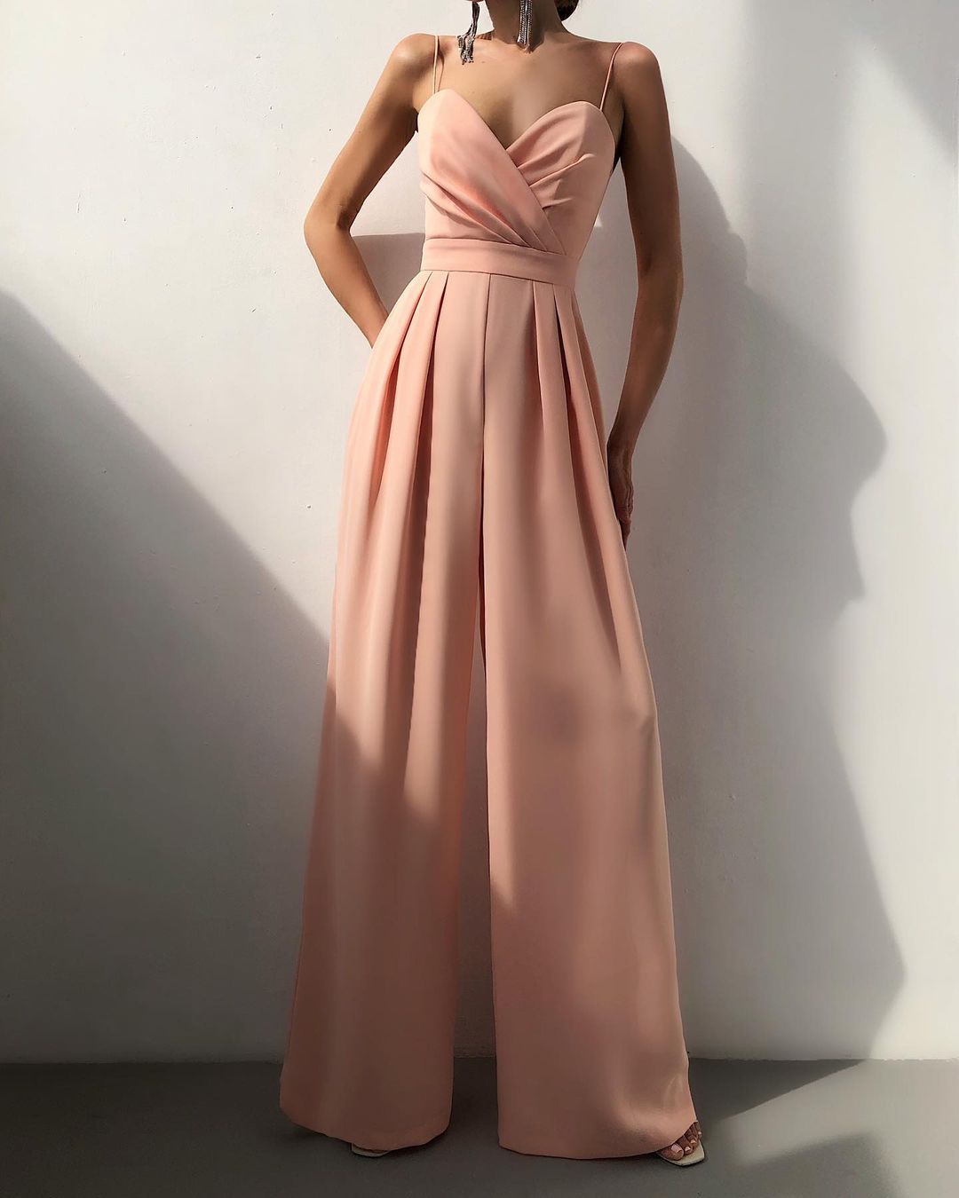 Tuta elegante con pantalone ampio e spalline sottili, un capo di moda femminile sofisticato per abbigliamento da sera.