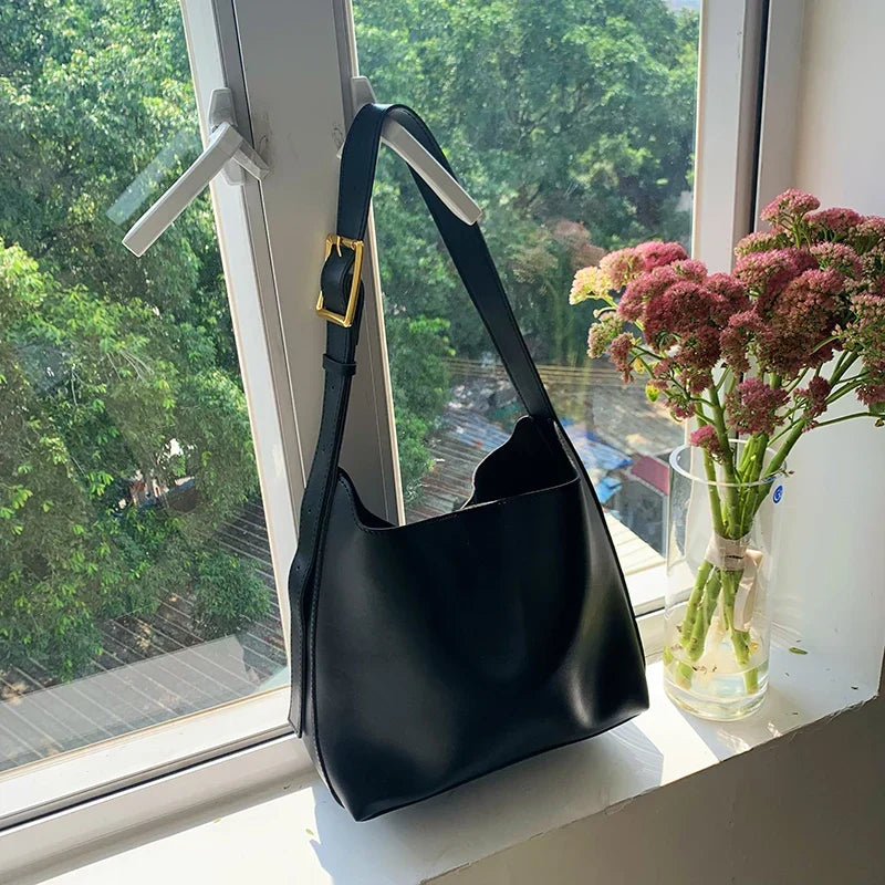 Donna che indossa la borsa shopper elegante nera a tracolla, mostra la sua praticità e il suo stile.