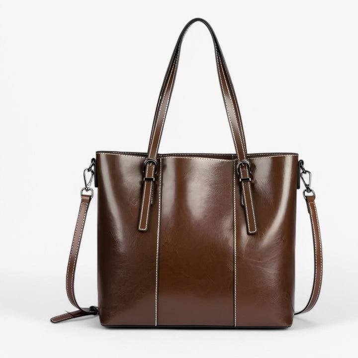 Donna indossa borsa tote marrone scuro, accessorio moda elegante e capiente per il quotidiano.