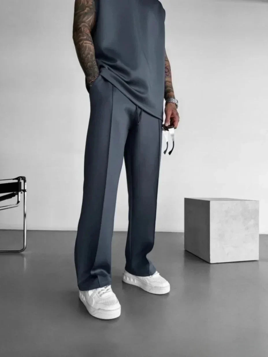 Set lounge casual uomo, top senza maniche e pantaloni sartoriali, per comfort e stile moderno.