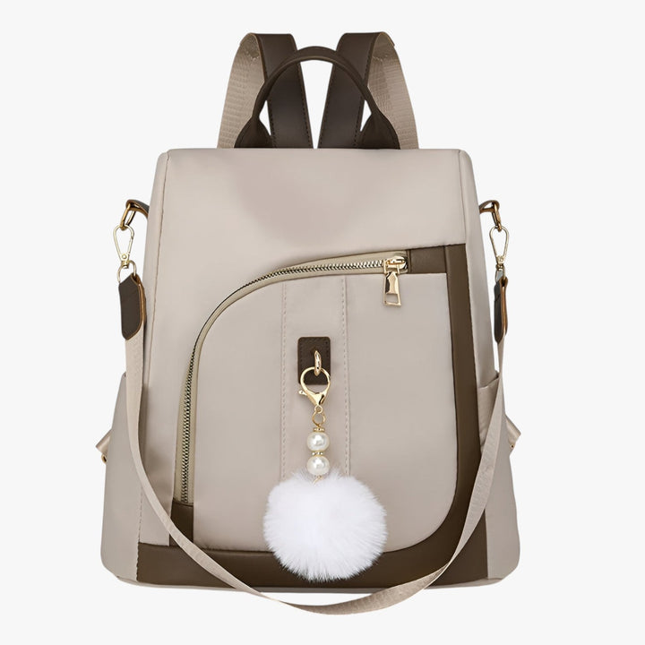 Zaino borsa donna versatile con pompon rimovibile, perfetto per ogni stile e occasione, disponibile in beige.