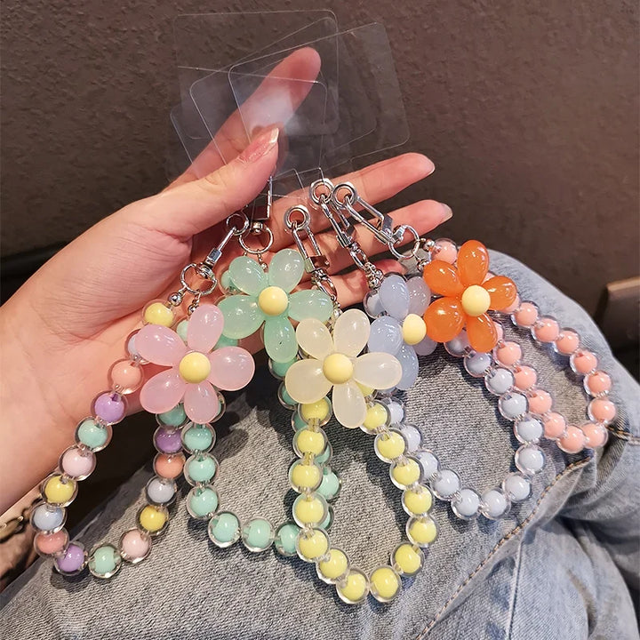 Laccetto telefono donna con perline macaron e fiore colorato, un accessorio moda da polso vivace.