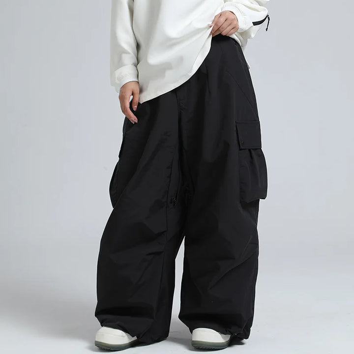 Uomo indossa pantaloni sci larghi, caldi e impermeabili. Outfit neve completo per sport invernali.