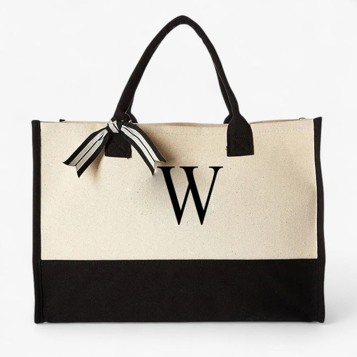 Tote bag personalizzabile con iniziale per donna. Borsa grande, versatile, beige e nera per uso quotidiano.