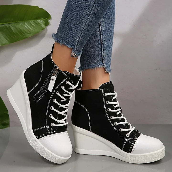 Sneakers donna nere con zeppa rialzata, zip decorativa e lacci. Stile moderno e funzionale.