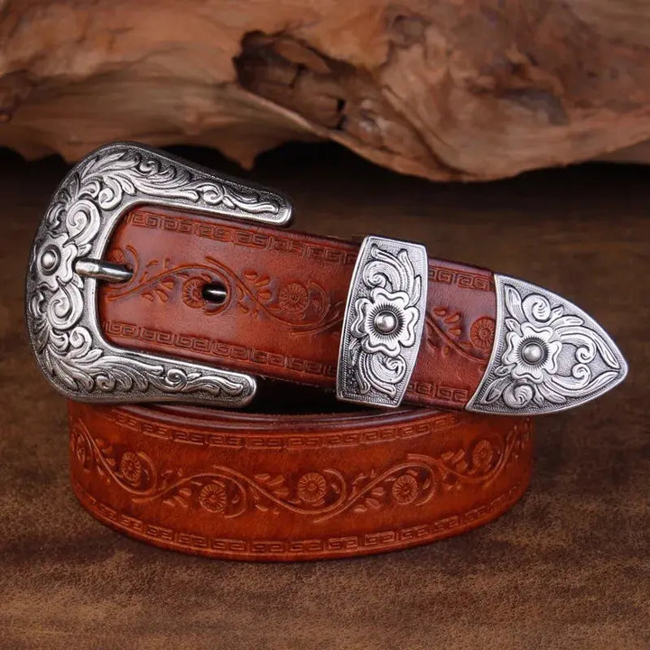 Fibbia incisa in metallo, dettaglio intricato di una cintura uomo western in vera pelle, stile cowboy autentico.