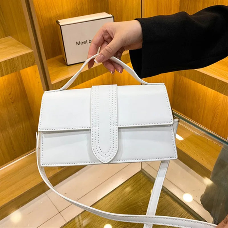 Dettaglio borsa a tracolla da donna con patta multicolore, un accessorio elegante e funzionale per il tuo stile.