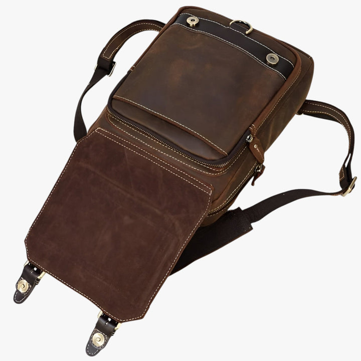 Zaino marrone frontale con due fibbie decorative e tasche esterne, perfetto accessorio unisex per ogni giorno.