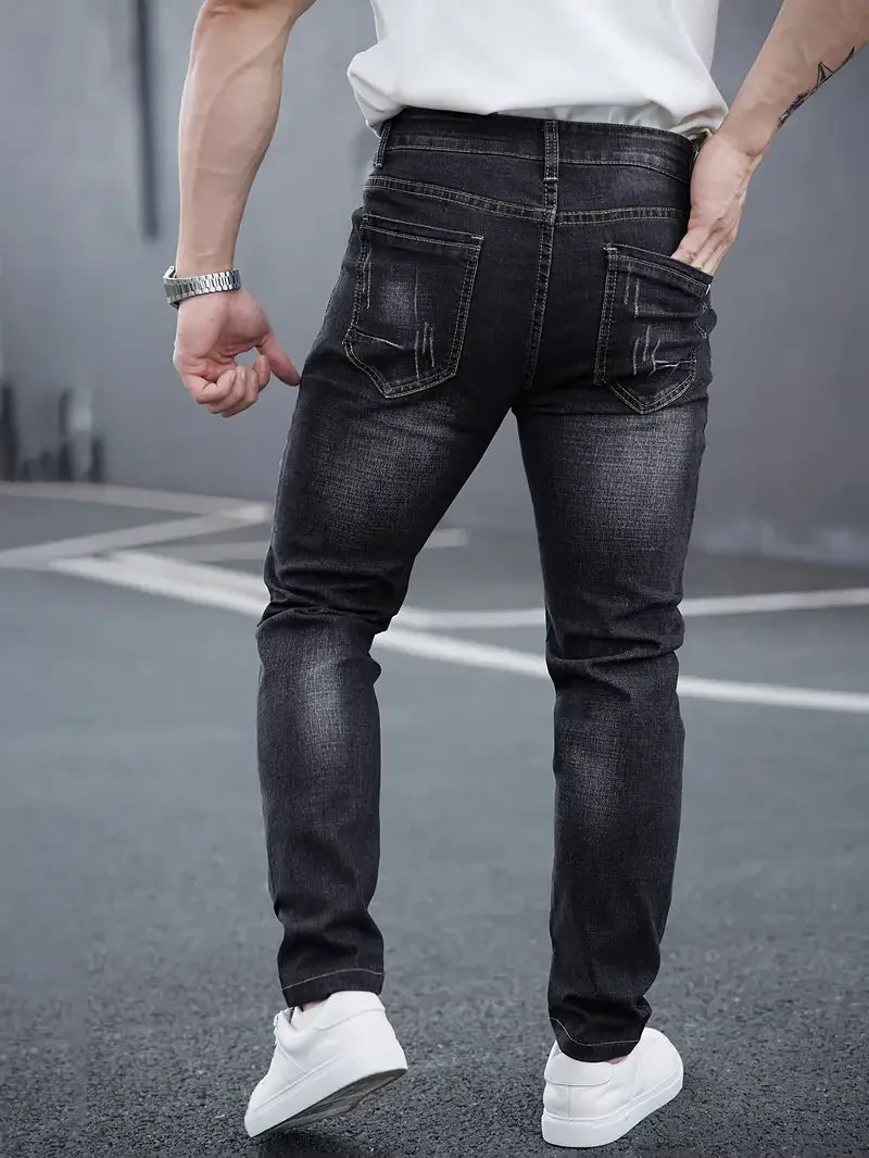Modello jeans uomo tapered vita media, chiusura bottoni. Denim blu scuro, vestibilità affusolata casual.
