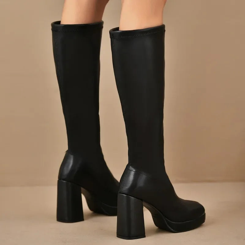 Splendidi stivali donna neri in pelle, sopra ginocchio con tacco e plateau. Stile invernale e moda elegante.