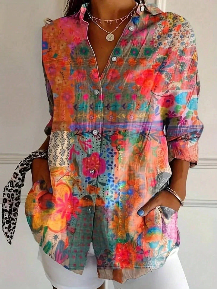 Blusa donna floreale multicolore con vivace stampa, maniche lunghe e taglio ampio, ideale per la moda estiva.
