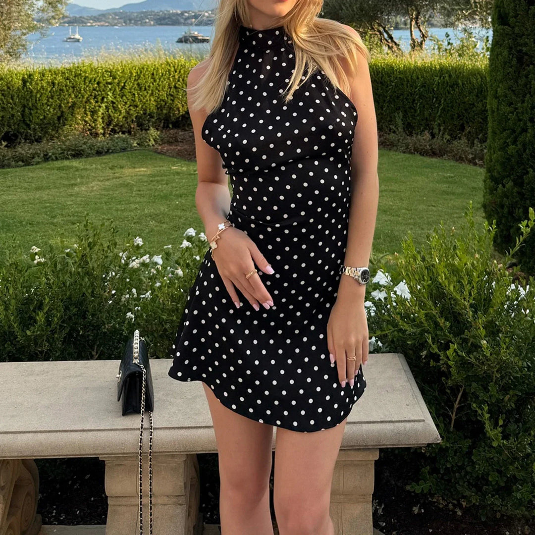 Vestito corto donna nero con pois bianchi, scollo all'americana. Abito elegante e retrò, ideale per feste.