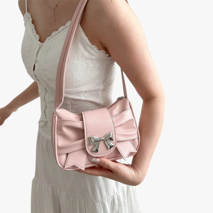 Pochette compatta da donna, mostrata indossata a mano, evidenziando praticità e stile unico.