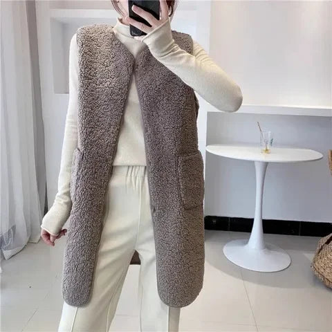 Donna indossa gilet lungo in misto lana, caldo e confortevole, per un outfit invernale chic e femminile.