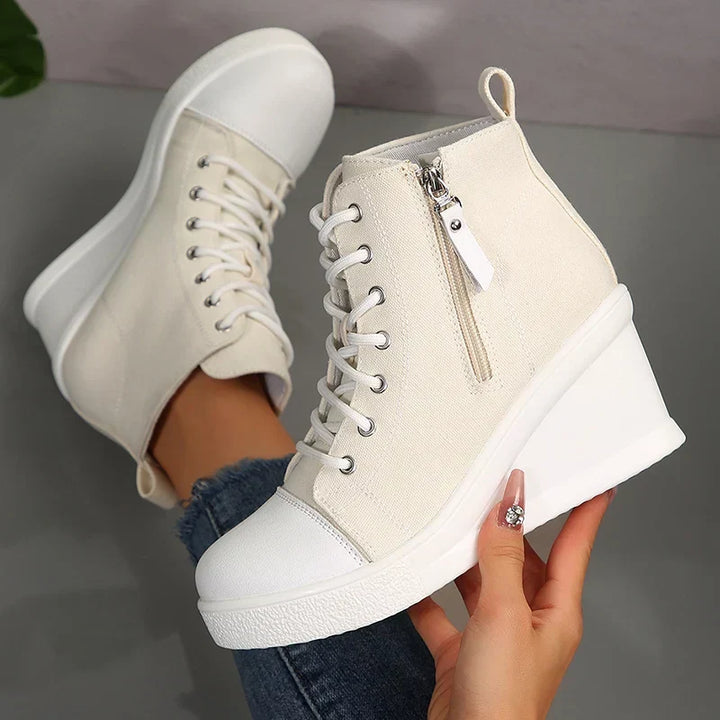 Eleganti sneakers donna con zeppa interna, zip laterale e lacci. Perfette per un look casual-chic.