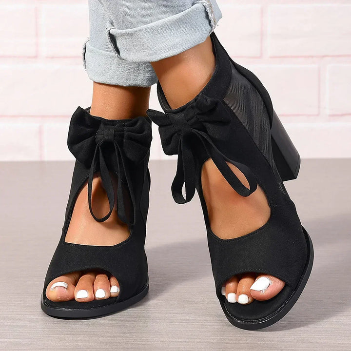 Moda donna: sandali eleganti neri con tacco a blocco, fiocco e rete. Ideali per cerimonie e serate glamour.