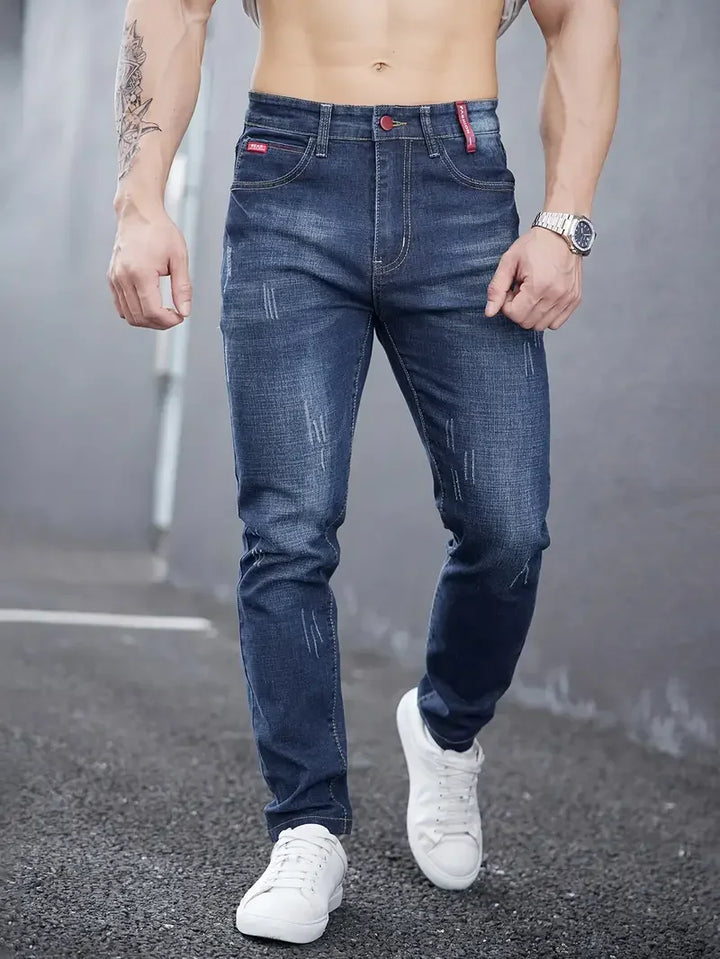 Abbigliamento maschile: jeans uomo tapered blu, vita media, chiusura bottoni. Vestibilità slim casual.