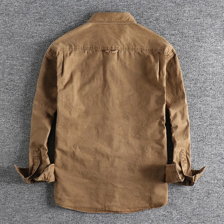 Dettaglio di camicia uomo a maniche lunghe con effetto lavato, stile rilassato per moda e abbigliamento maschile.