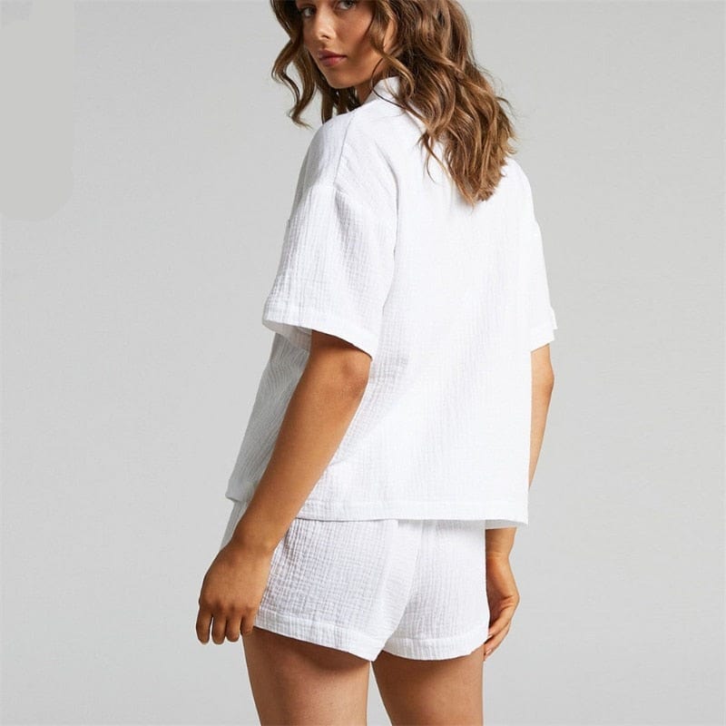 Elegante completo due pezzi donna estivo: camicetta bianca e pantaloncini verdi a vita alta, casual chic.