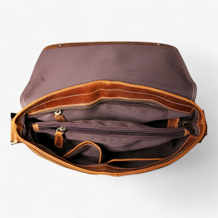 Primo piano della tracolla regolabile e fibbie della borsa messenger marrone unisex.