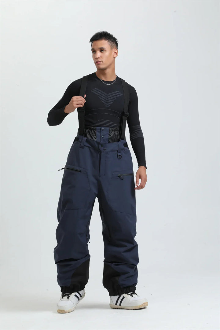 Dettaglio dei pantaloni da sci unisex neri, con bretelle regolabili e tessuto impermeabile per neve.