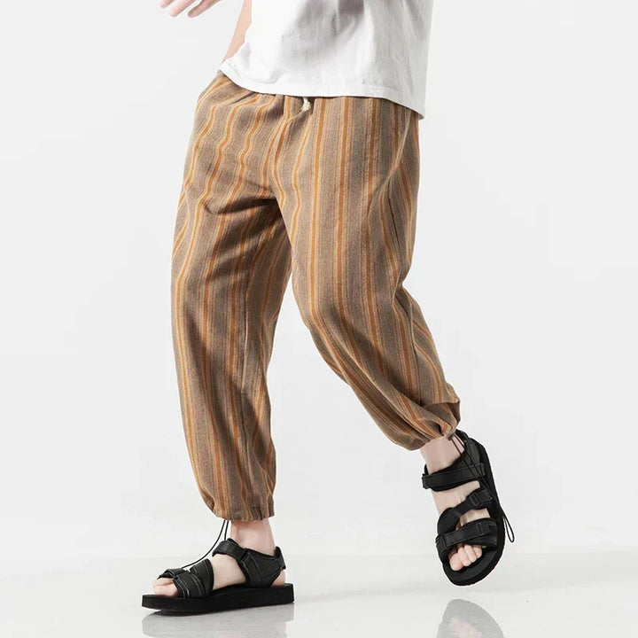 Uomo indossa pantaloni harem a righe sottili, vestibilità comoda e regolabile. Perfetti per un look casual e relax.
