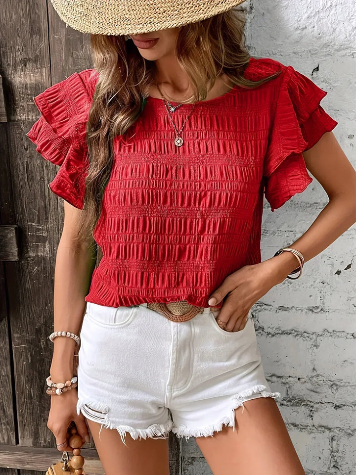 Top donna elegante con volant, ideale per outfit da ufficio o serate, aggiunge un tocco chic.
