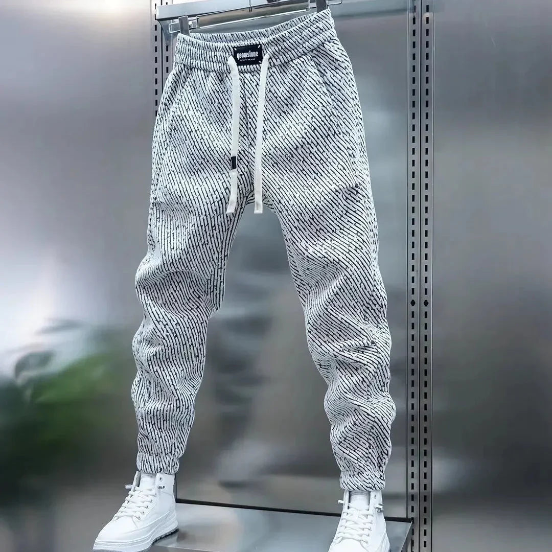 Uomo indossa pantaloni slim fit casual a fantasia con vita elasticizzata. Perfetti per un look sportivo e alla moda.