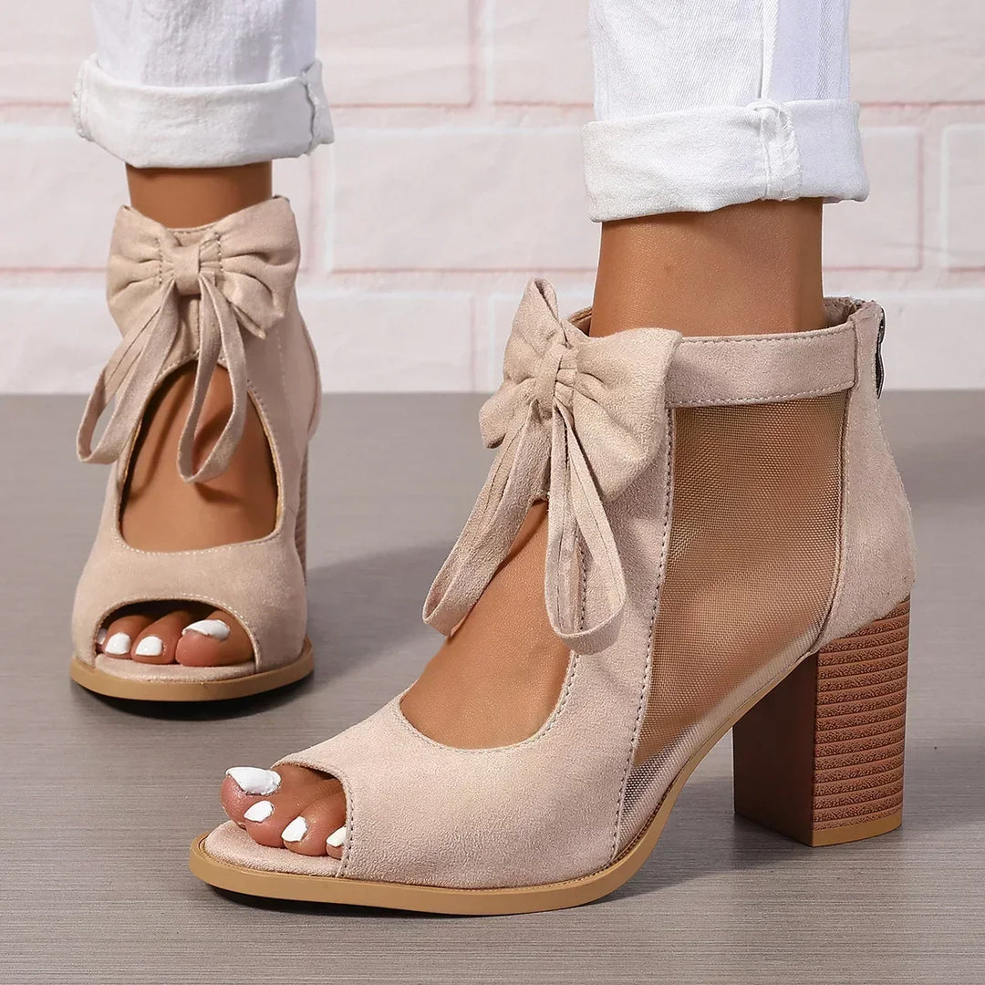 Sandali estivi da donna beige con comodo tacco a blocco, fiocco chic e inserti in rete. Calzature eleganti.