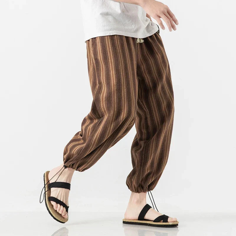 Dettaglio pantaloni harem uomo in tessuto leggero, righe sottili. Comodi per primavera/estate, stile rilassato.