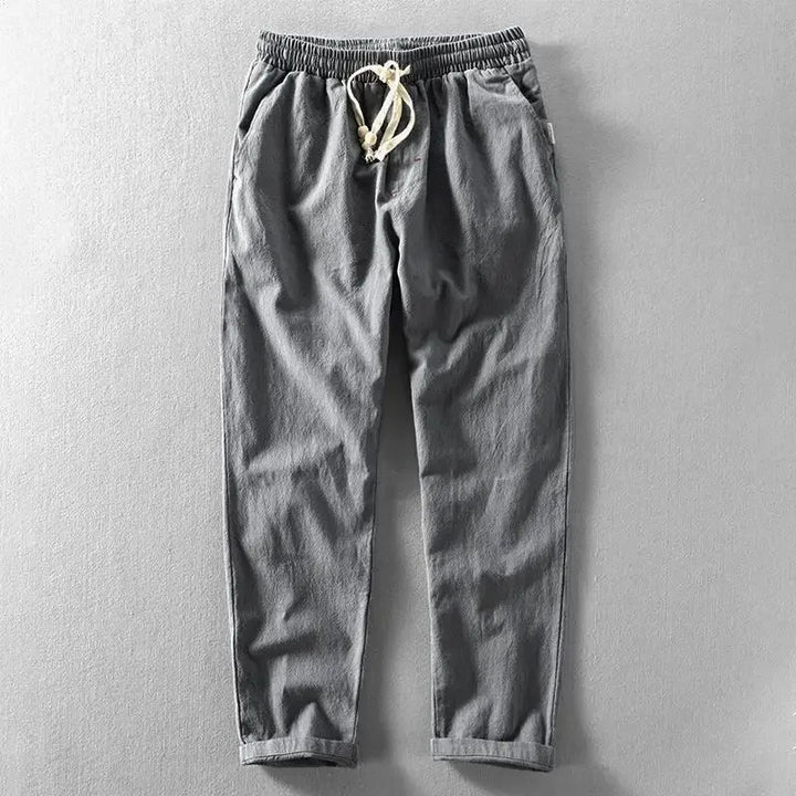 Uomo indossa pantaloni in lino, stile rilassato e confortevole, perfetti per il clima estivo.