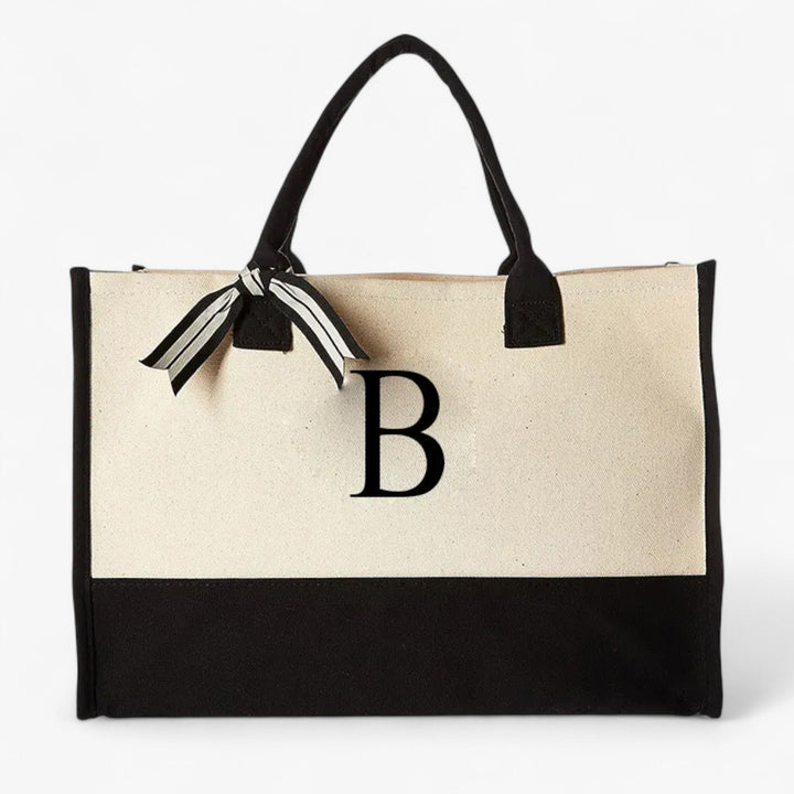 Borsa tote personalizzabile beige e nera con iniziale. Comoda e grande, perfetta per la donna moderna.