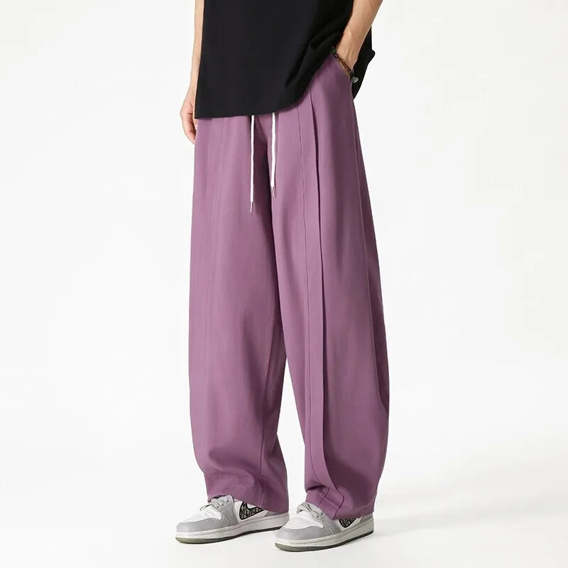 Dettaglio coulisse e vestibilità comoda dei pantaloni jogging uomo a gamba larga, look streetwear moderno.