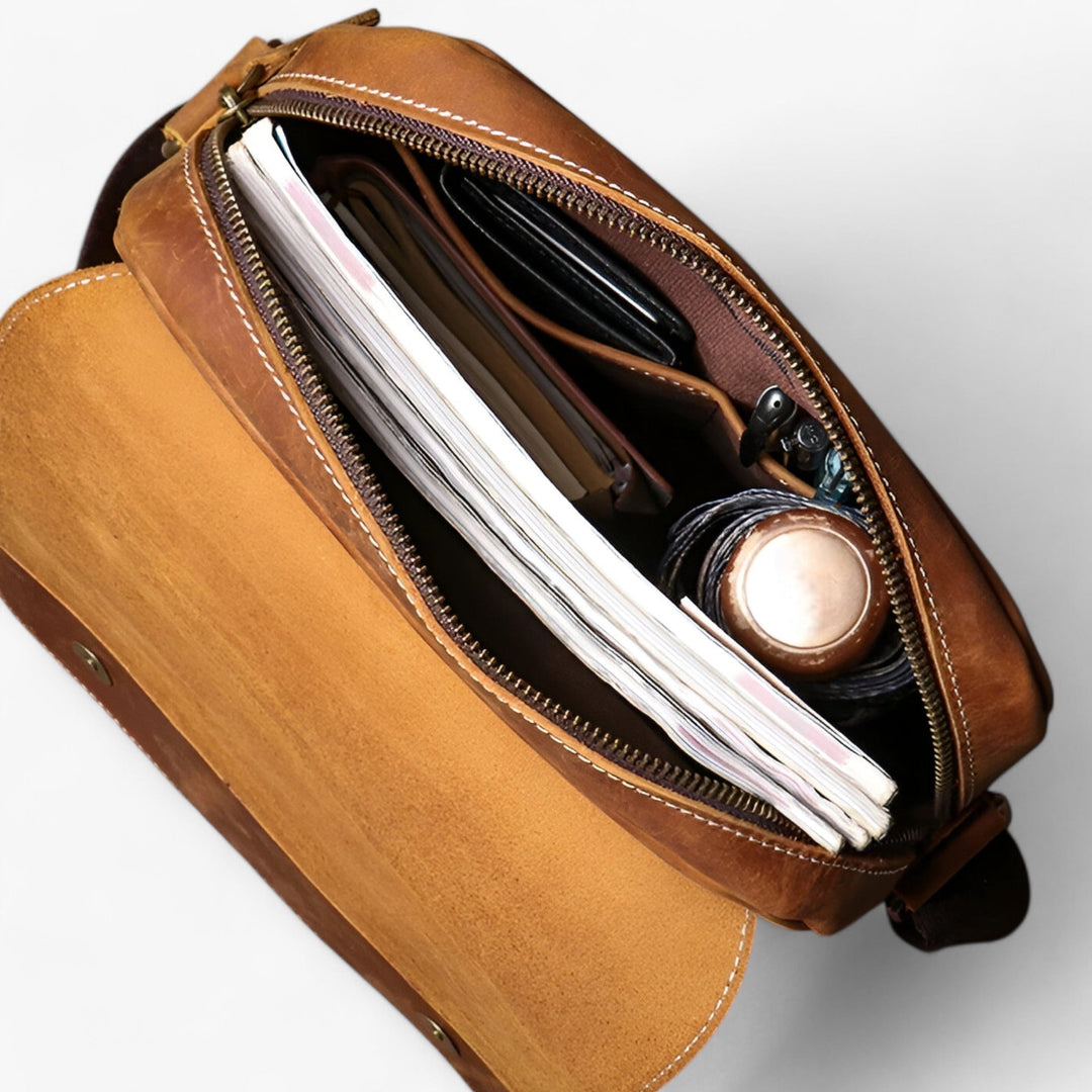 Dettaglio tessuto sintetico resistente della borsa messenger marrone unisex, duratura e pratica per ogni giorno.