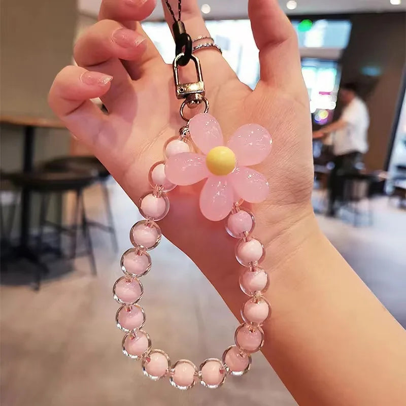 Porta telefono da polso donna, laccetto con perline macaron e fiore, accessorio chic e funzionale.